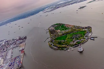 Aerial view of Governors Island in New York
                        Harbor off the tip of Manhattan, with the
                        Statue of Liberty visible in the distance.