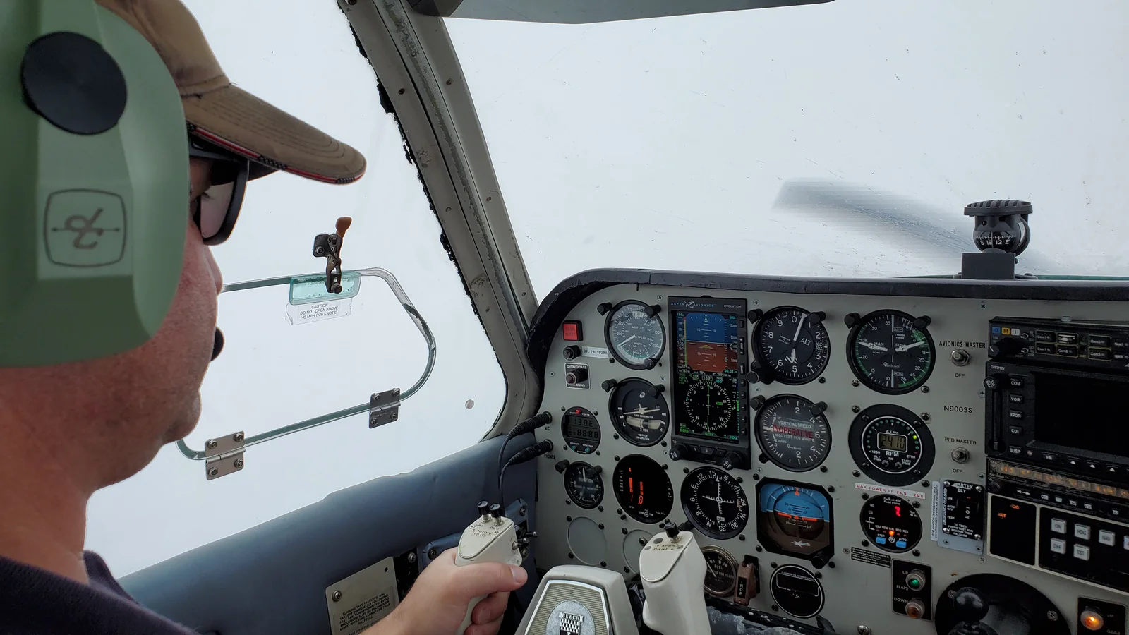 Light-aircraft cockpit in flight with the windscreen
                  completely white — solid cloud in instrument
                  meteorological conditions.