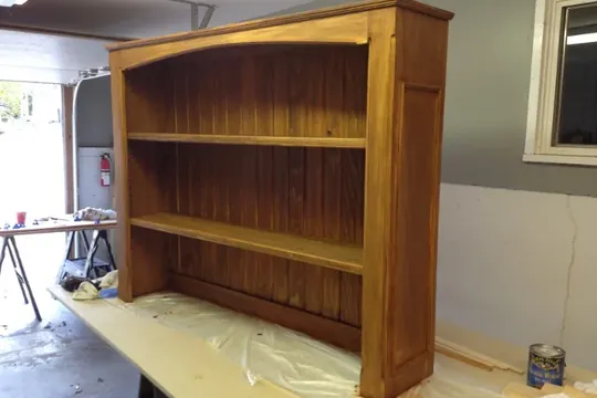 A finished stained wooden hutch standing in the
                      workshop.